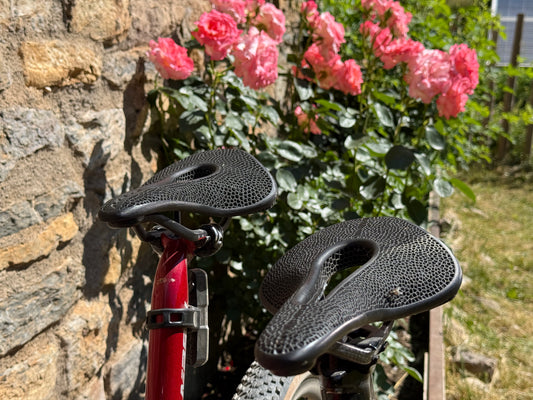 Dos sillines Carbon 3D NEXUS apoyados en una bicicleta, al aire libre