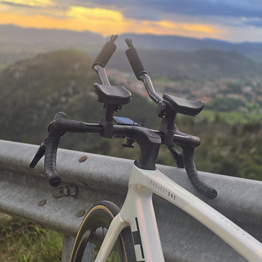 Bici de carretera con cabina de acoples CarboXtrem y apoyos de malla 3D ante un valle al atardecer