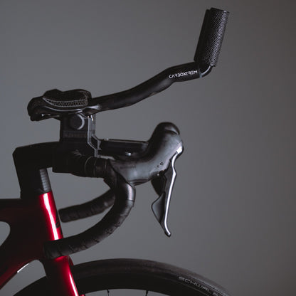 Acople aero CarboXtrem de perfil sobre una bici de carretera roja, junto a la maneta Shimano