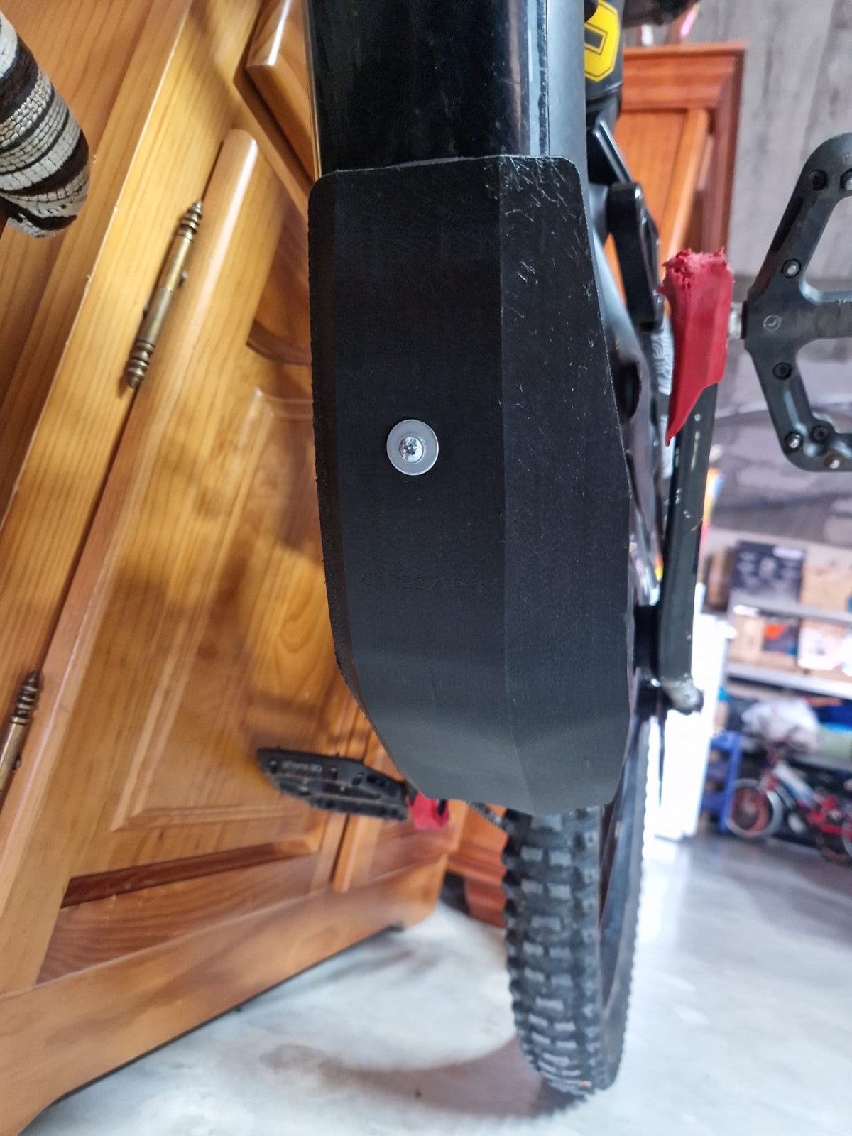 Protector de cárter CarboXtrem montado bajo el motor de una bicicleta eléctrica