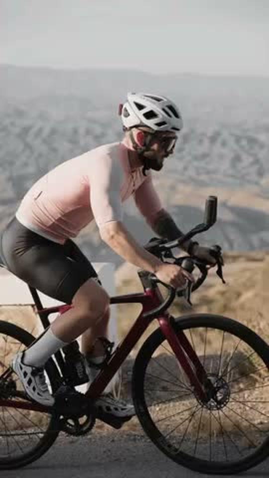 Ciclista rodando por carretera de montaña con acoples aerodinámicos CarboXtrem